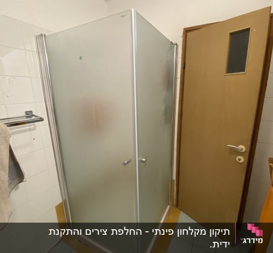מקלחון בחדר אמבטיה עם דלת פתוחה